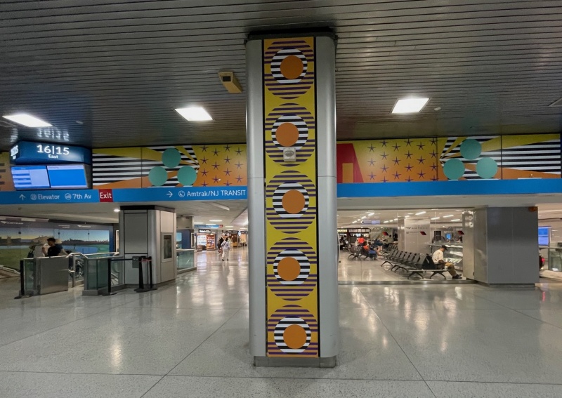 Vinyl graphics are printed and installed to wrap columns and overhead spaces in art installation in Penn Station , NYC