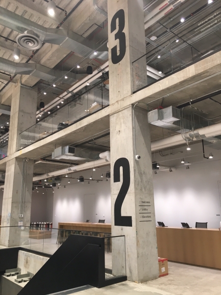 Wayfinding signage screen printed on concrete columns corporate interiors NYC