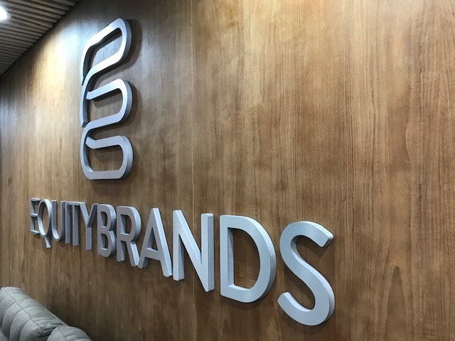 Brushed metal dimensional corporate logo installed in showroom for branding